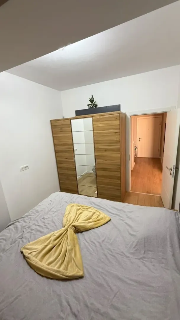 Spavaća soba sa krevetom i drvenim garderoberom.