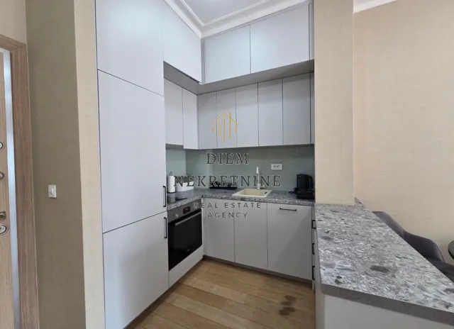 Modern kitchen with light-colored cabinets and a breakfast bar.