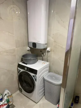 Bathroom with a washing machine and a water heater on the wall. - image 10