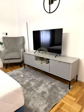 Bedroom with a TV cabinet and an armchair. - image 8