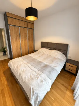 Modern bedroom with a double bed, large wooden wardrobe, and bedside tables. - image 8