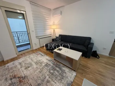Living room with a sofa, coffee table and balcony access. - image 11