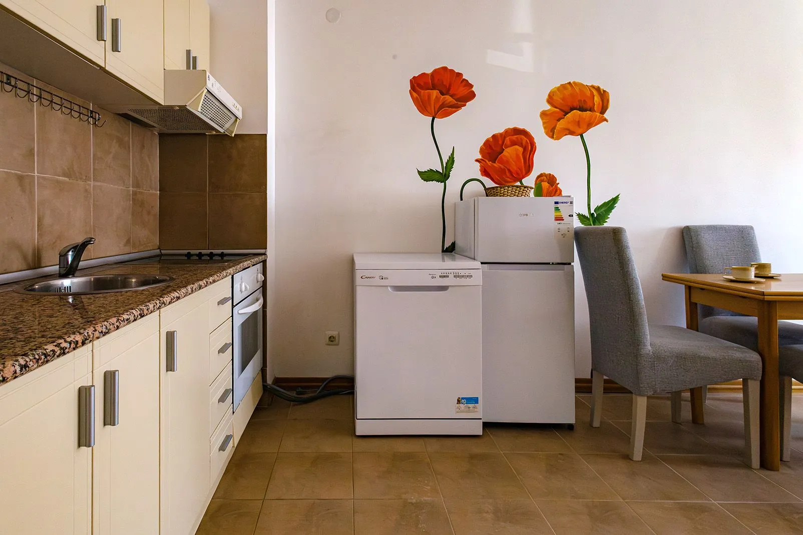 Smaller kitchen with a dining area and decorative wall stickers.