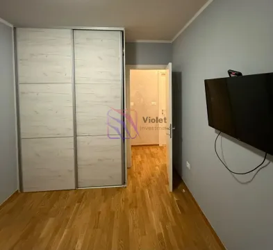 Bedroom with a large built-in wardrobe and a wall-mounted TV. - image 12