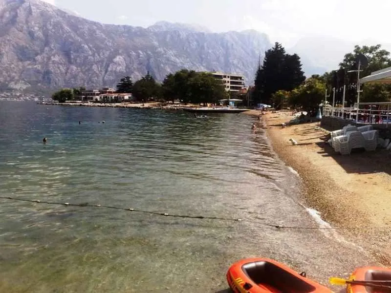Pogled na plažu i more sa planinama u pozadini.