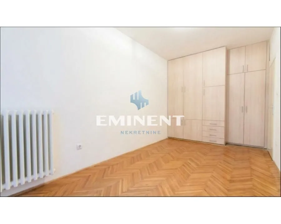 Empty bedroom with a built-in wardrobe and parquet flooring.