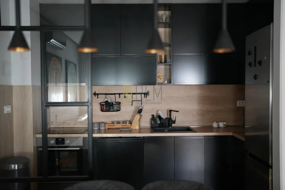 Modern kitchen with dark cabinetry and wooden details.