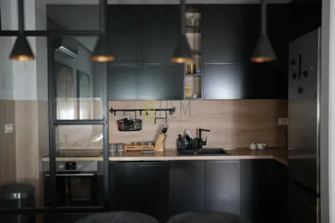 Modern kitchen with dark cabinetry and wooden details. - image 7