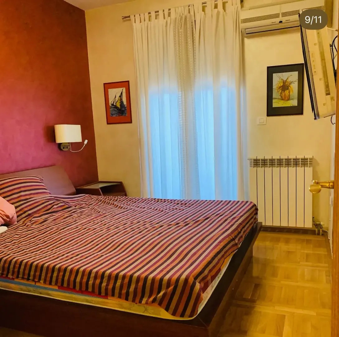 Namještena spavaća soba sa bračnim krevetom.