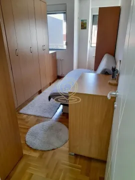 Manja spavaća soba sa krevetom, velikim plakarom i parketom na podu. - image 4