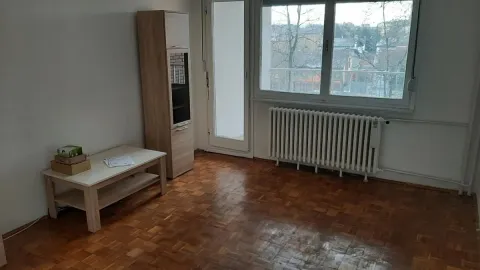Prazna prostorija sa parketom, drvenom vitrinom i malim stočićem pored prozora. - image 2