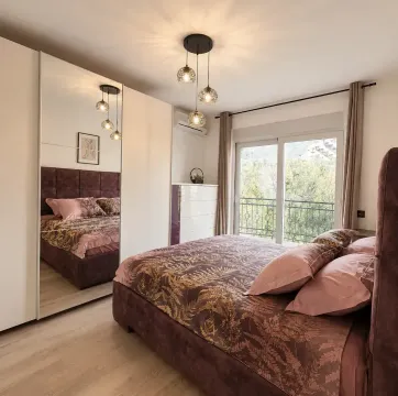 Namještena spavaća soba sa velikim bračnim krevetom, garderoberom sa ogledalom i izlazom na terasu. - image 9