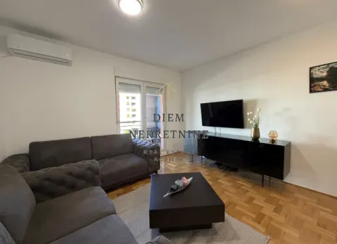 Comfortable living room with a sectional sofa, TV, and parquet flooring. - image 4