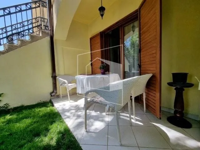 Terrace with table, chairs, and access to the yard.