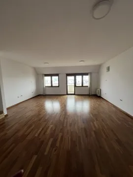 A spacious empty room with wooden flooring and balcony access. - image 4