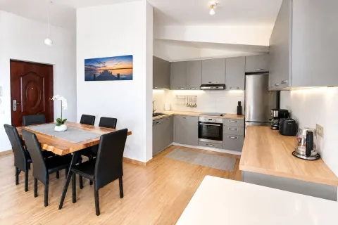 Modern kitchen with dining area and grey cabinetry. - image 4