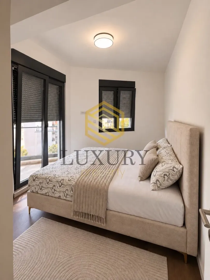 Bright bedroom with a double bed and balcony access.