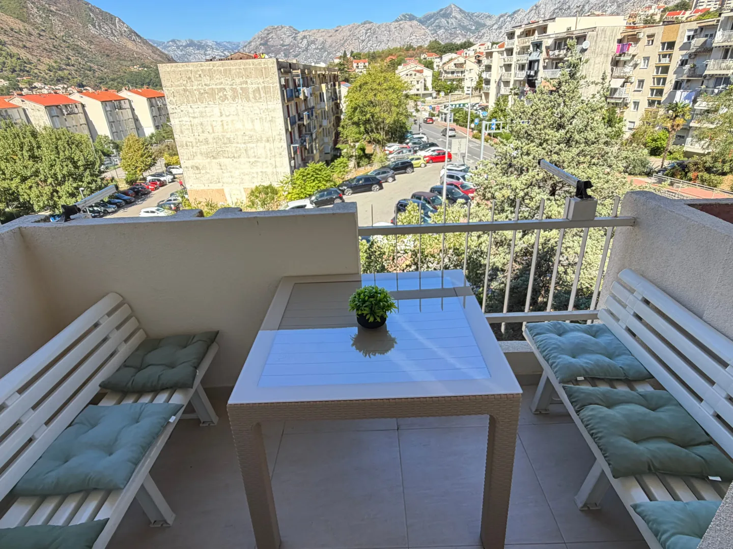 Natkriveni balkon sa garniturom za sjedenje i pogledom na grad.