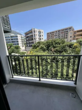 View from the apartment balcony of surrounding buildings and greenery. - image 6