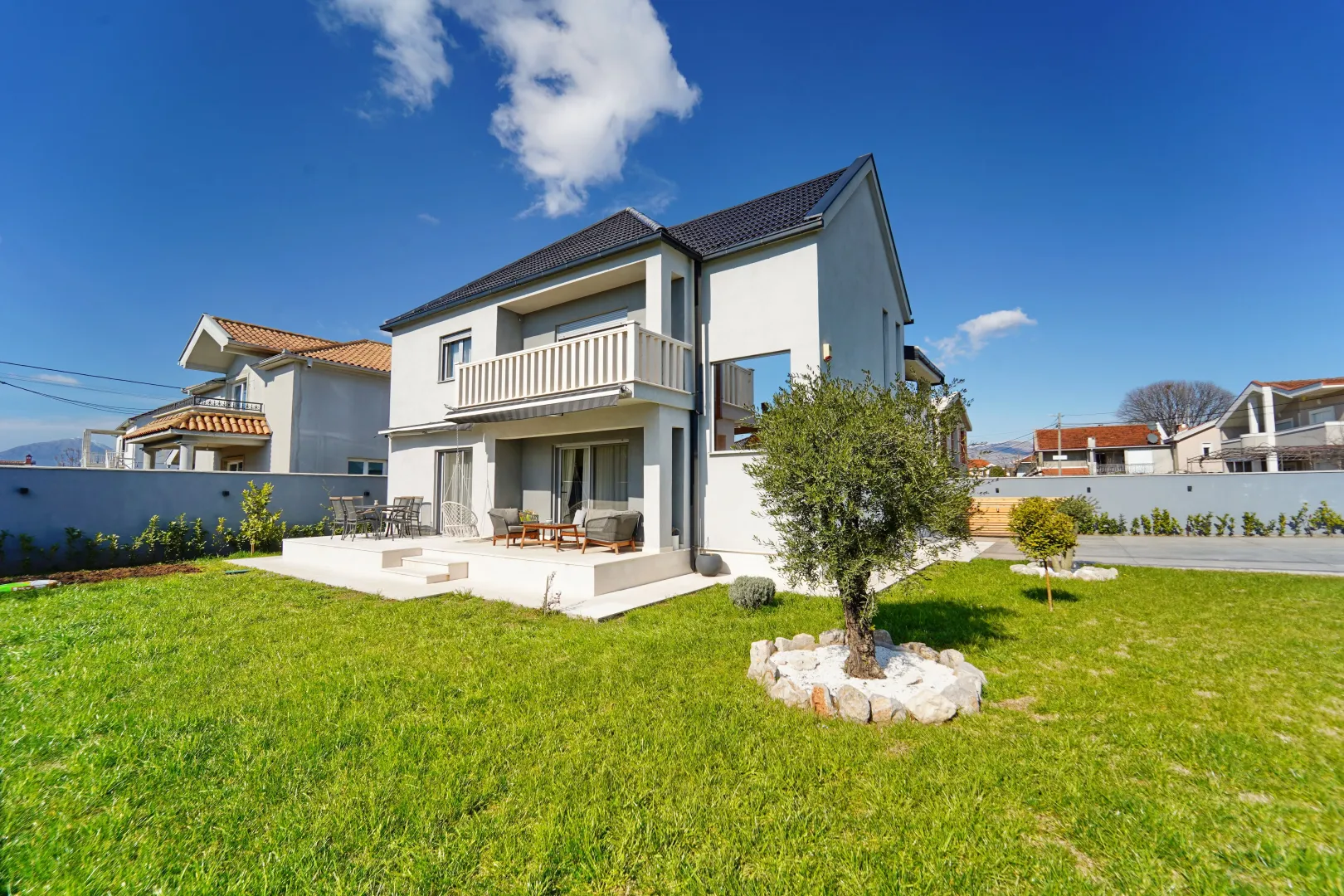 Modern two-story house with a landscaped yard and lawn.