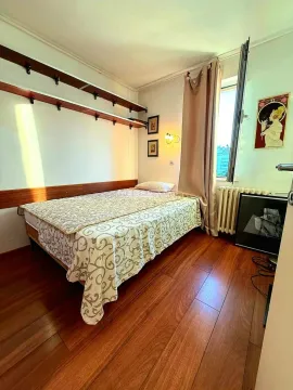 Furnished bedroom with a double bed, wooden floor and a window. - image 9