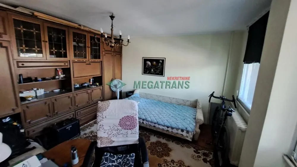 Nameštena spavaća soba sa velikim drvenim ormarom i krevetom.