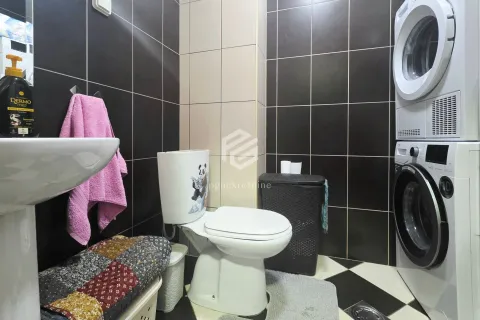 Kupatilo sa toaletom, umivaonikom i složenim mašinama za pranje i sušenje veša. - image 5