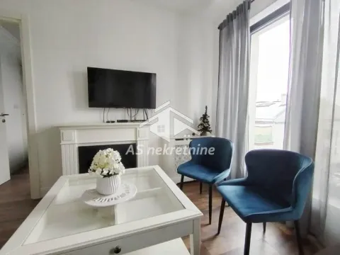 Living room with fireplace, TV, coffee table and blue armchairs. - image 2