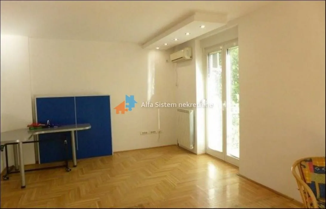 Empty room with parquet flooring and balcony doors.