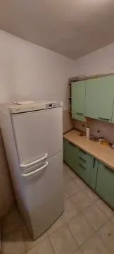 Kuhinja sa bijelim frižiderom i svijetlozelenim elementima. - image 14