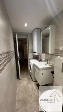 Small bathroom with a sink, washing machine, water heater, and toilet. - image 6