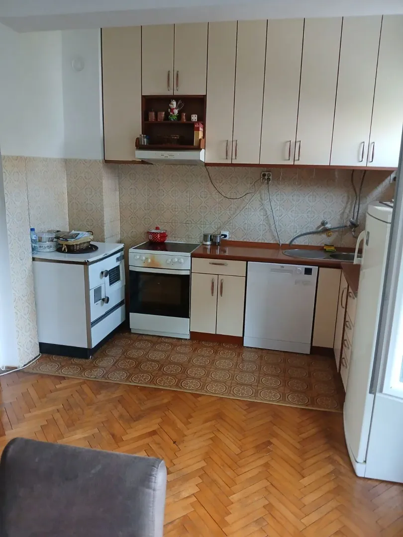 Funkcionalna kuhinja sa svijetlim elementima i parketom.
