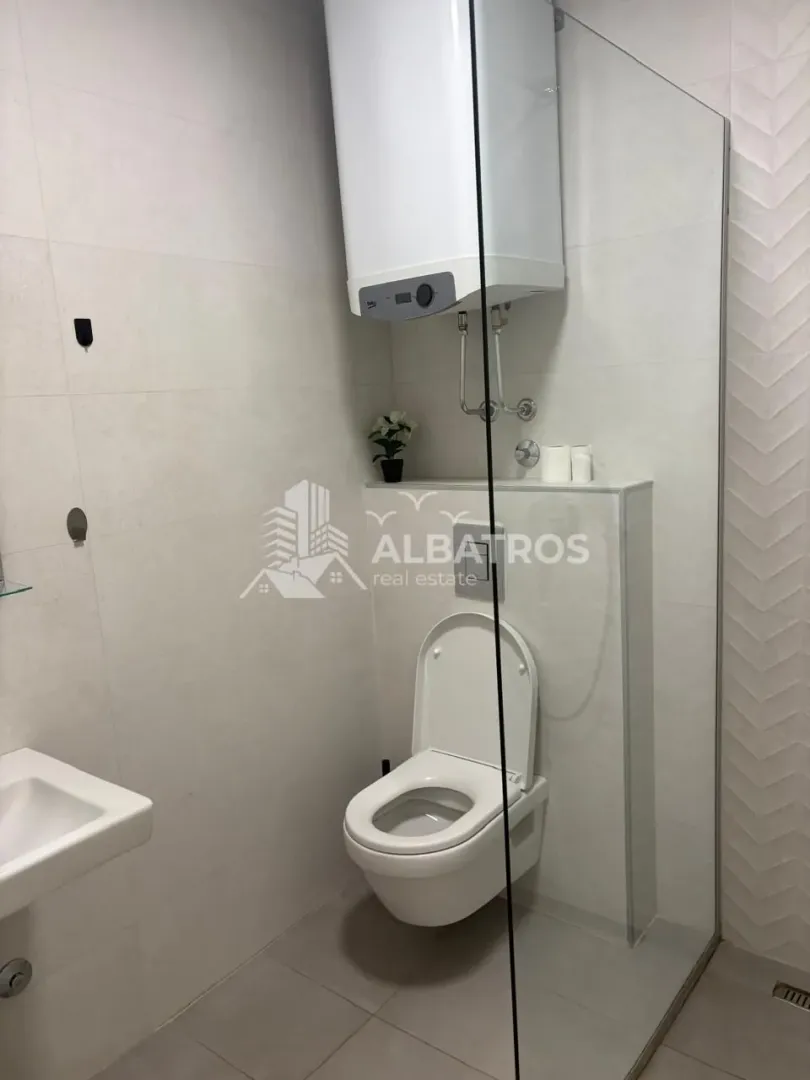 Moderno opremljeno kupatilo sa tuš kabinom i wc šoljom.