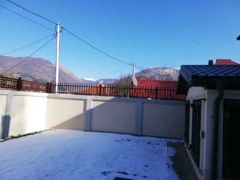 Pogled na ograđeno dvorište pokriveno snijegom i okolne planine. - image 26