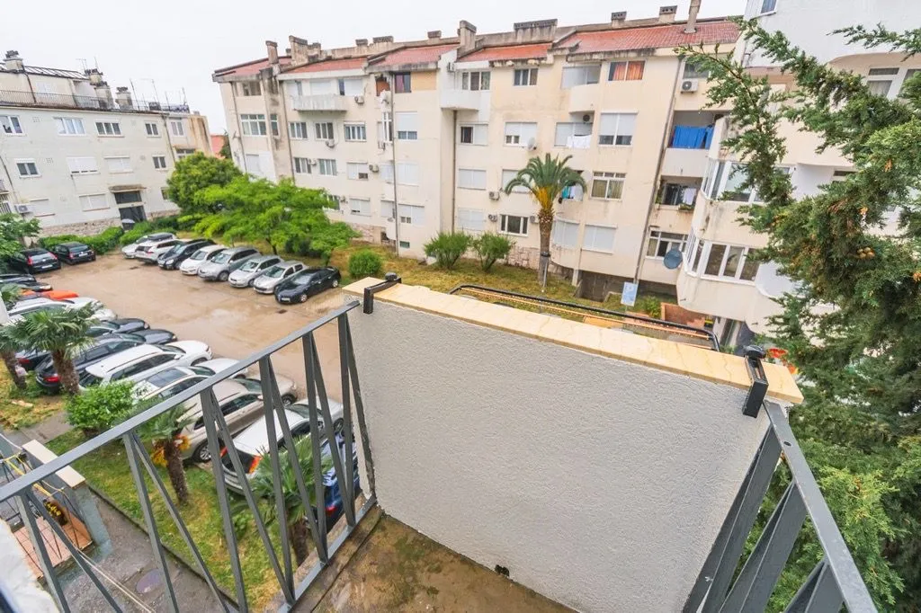 View from the balcony overlooking the residential building and parking lot.
