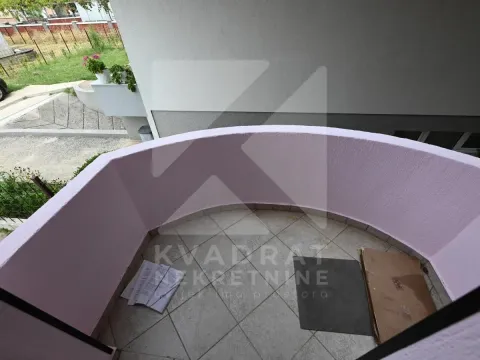 Small semicircular balcony with tiled flooring and a view of the yard. - image 3