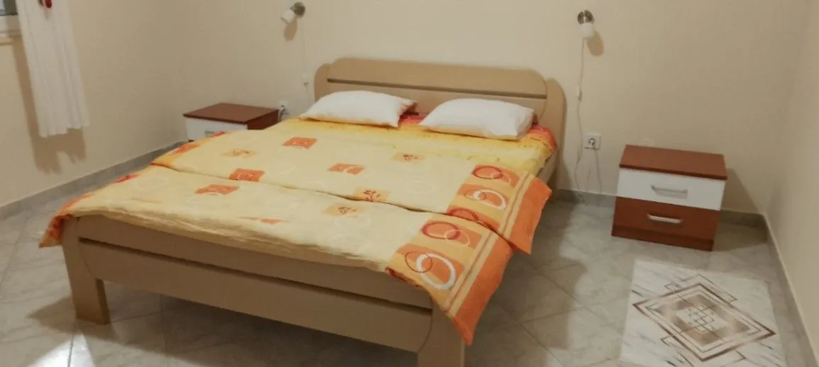 Spavaća soba sa bračnim krevetom i noćnim stočićima.