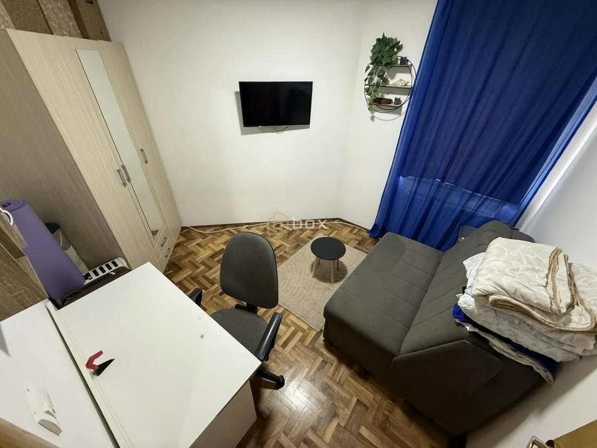 Manja soba sa krevetom na razvlačenje, radnim stolom i ormarom.