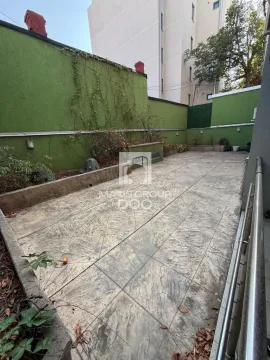 Paved courtyard with a wall and greenery. - image 17