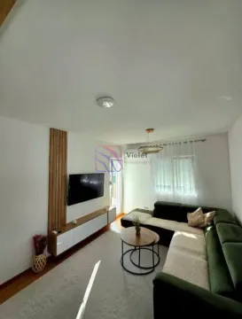 Living room with a corner sofa, television, and coffee table. - image 2