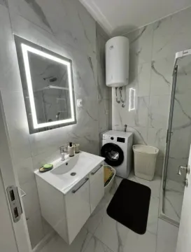 Moderne opremljeno kupatilo sa tuš kabinom, umivaonikom i veš mašinom. - image 7