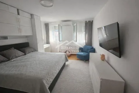 Furnished bedroom with a double bed, white cabinet, and wall-mounted TV. - image 7