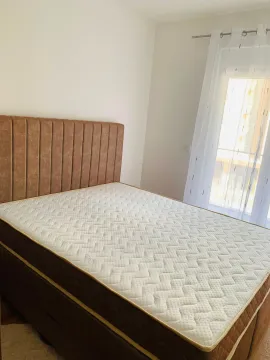 Svijetla spavaća soba sa bračnim krevetom i prozorom prekrivenim zavjesama. - image 11
