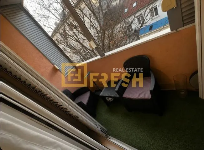 Manji zatvoreni balkoni sa garniturom za sjedenje i vještačkom travom na podu.