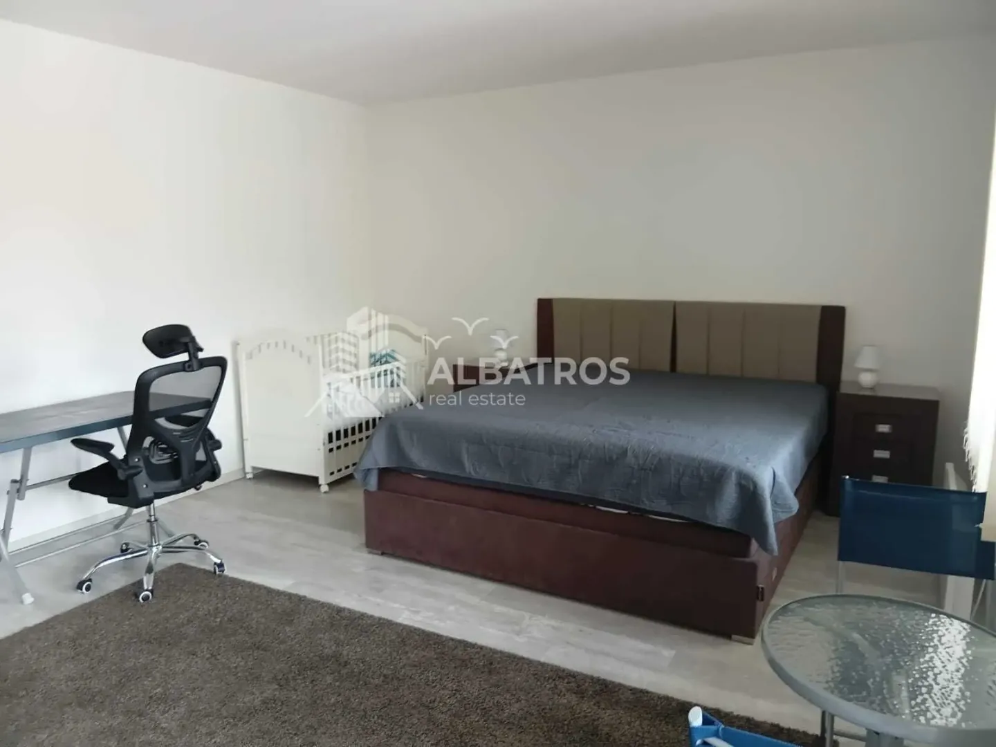 Spacious bedroom with a double bed, cot and a desk.