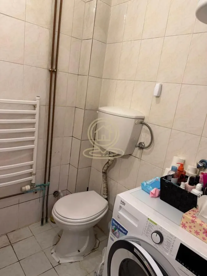Manje kupatilo sa toaletom i veš mašinom.