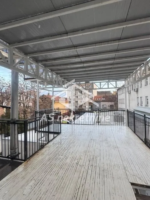 Large covered terrace with a metal railing and city views.