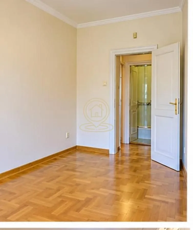 Empty room with parquet flooring and an open door leading to the hallway.