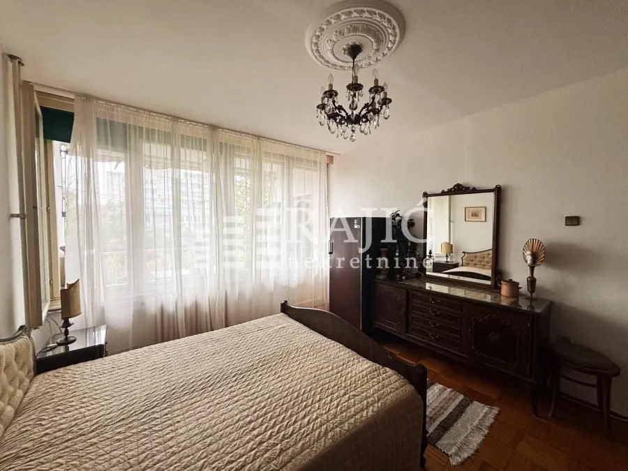 Furnished bedroom with a large double bed and dresser.