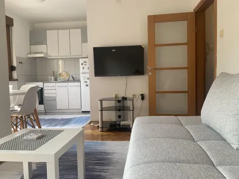 Svijetla dnevna soba sa garniturom za sjedjenje spojena sa kuhinjom. - image 10